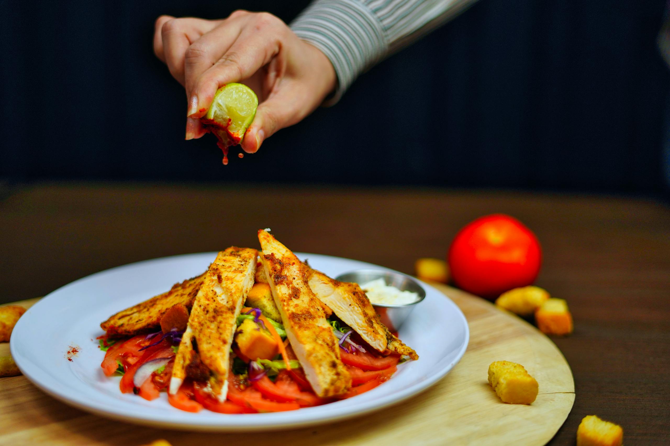 A vibrant grilled chicken salad with fresh lime squeeze and colorful veggies.