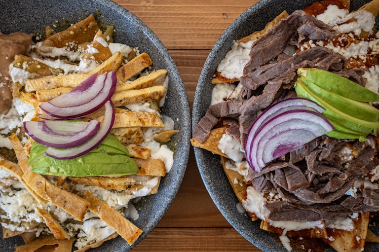 Delicious Mexican chilaquiles topped with avocado and beef, capturing traditional flavors in Santiago de Querétaro.